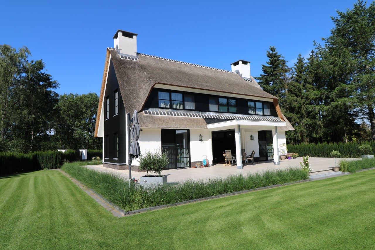 Rietgedekte villa met veranda en tuin
